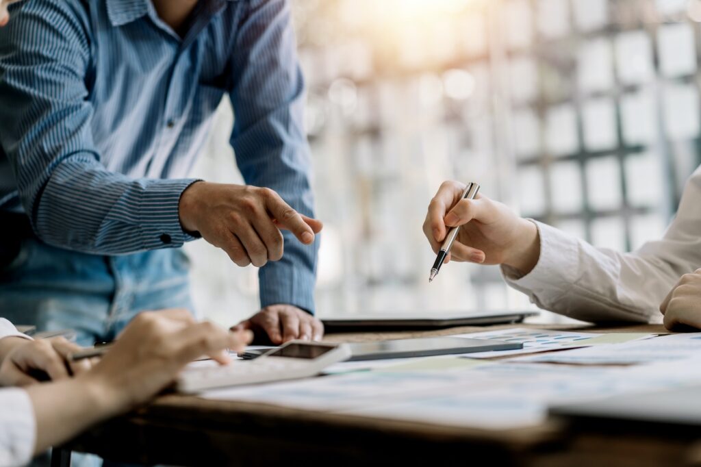 Business team working together planning investment at meeting. Close up view of business people advi